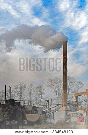 Smoke, Air Emissions From An Industrial Pipe Against Trees. Pollution Of The Environmen.