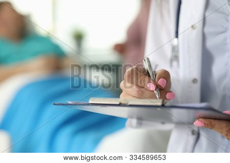 Focus On Female Hand Holding Paper Folder And Writing In Important Documents By Pen. Female Doctor A
