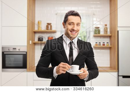 Businessman with a cup of espresso coffee in a ktichen