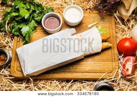 Hot Shawerma With Sauce And Parsley On Wooden Plate In Studio