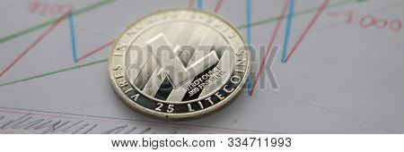 Focus On Ltc Cryptocurrency Lying On Documents With Statistics Data With Graph Of Growth Income. E-b