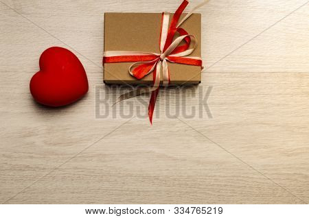 Gift Or Present Box With Red And Whight Bow Ribbon And Glitter Heart On Wooden Table For Valentines 