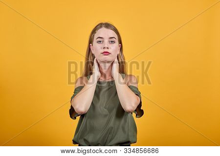 Close Up Brunette Isolated On Beige Orange Wall Background, Studio Portrait, Keeping Hand On Neck We