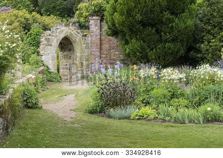 An Ancient Stone Arch In A Formal Garden In Kent, England