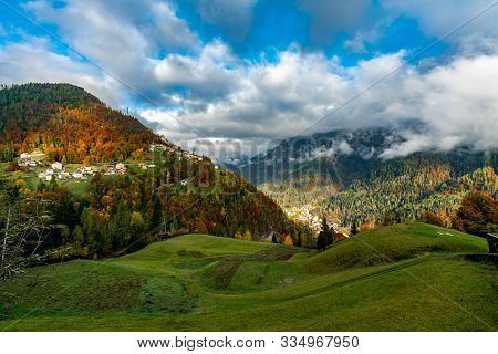 Colourful Aumtumn View Across The Cordevole Valley With Avoscan, Pecol And Piaia Villages In The Bac