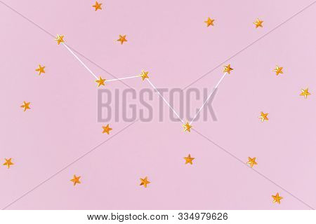 Orange Rhinestones In Form Of Stars Are Laid Out In The Constellation Cassiopeia. Pastel Pink Backgr