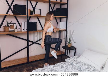Attrctive Fitness Woman Doing Stretching Exercises At Home, As Part Of A Healthy Lifestyle Without G