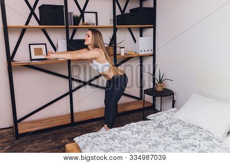 Attrctive Fitness Woman Doing Stretching Exercises At Home, As Part Of A Healthy Lifestyle Without G