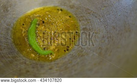 Close Up Of Golden Texture Of Shining Yellow Hot Oil Boiling And Creating Bubbles In A Silver Pan.