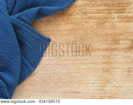 Top View, Close-up Of Blue Fabric Or Napkin On Wooden Table Background. Concept Kitchen Utensils And