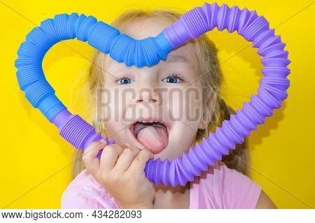 Pop Tube. Anti Stress Sensory Plastic Toy From A Pop Tube In The Hands Of A Child. Cheerful Little G