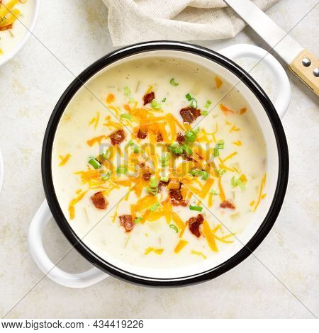 Close Up View Of Creamy Potato Soup With Bacon And Cheddar Cheese In Bowl On Light Stone Background.
