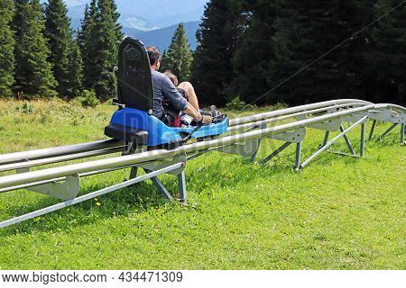 Father And Son Enjoying A Summer Fun Roller Alpine Coaster Ride In Rogla, Slovenia