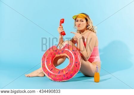 Full Length, Irritated Resentful Woman In Bathing Suit Sitting With Rubber Ring And Pointing At Phon