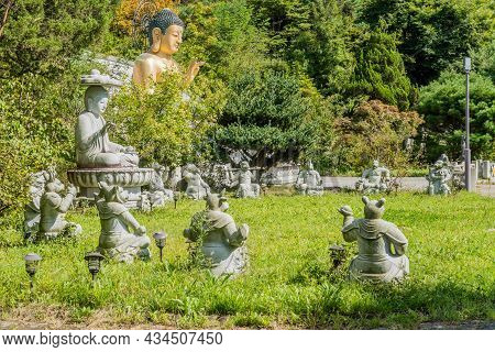 Statues Of Animals Of Chinese Horoscope And Seated Stone And Bronze Buddha In Garden Of Buddhist Tem