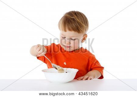 Little boy mangiare la farina d'avena