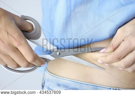 Woman Cuts Off Excess Skin And Fat From Abdomen And Sides With Scissors
