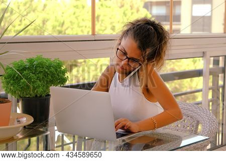 Young Woman Working From Home On Her Laptop Computer.