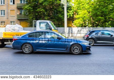 Bmw 5 Series G30 On The Road In Motion. Fast Speed Drive On City Road. Side View Of Moving Blue Car 