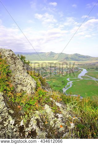The Edge Of A Cliff Above A Mountain Valley Under A Blue Cloudy Sky. Siberia, Russia