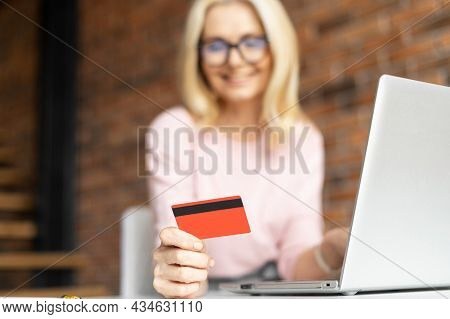 Selective Focus At The Debit Card In Hand Of Pretty Mature Businesswoman Wearing Glasses Sitting At 