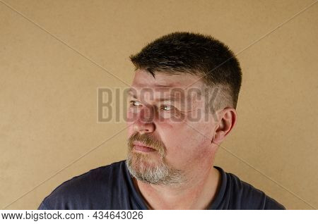 Portrait Of A 45 Year Old Man Looking Away. Adult Unshaven Male Indoors.