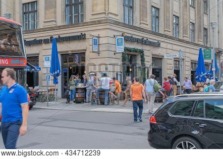 Berlin Germany - August 26 2017; People At Pavement Cafe Tables While Others Blurred In Motion Cross