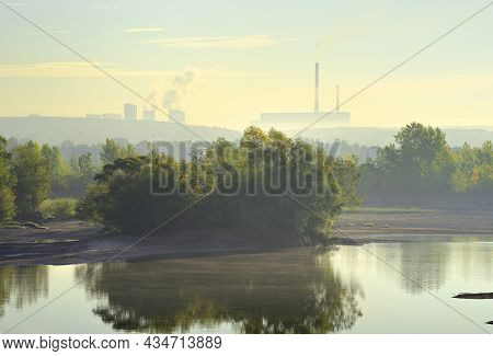 The Bank Of The Ob River In The Morning Fog. Chpp-5 Pipes In The Distance On The Horizon
