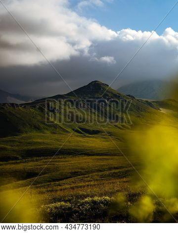 Beautiful photography of the mountain Oshten. Dramatic sky in the background and sun rays. Idea of tourism and hiking, breathtaking nature. High mountain in Russia.