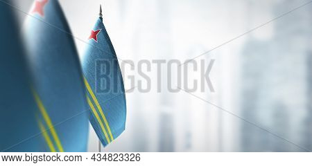 Small Flags Of Aruba On A Blurry Background Of The City