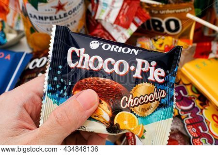 Tambov, Russian Federation - October 30, 2020 Person Hand With Orion Choco Pie Chocochip And Orange 