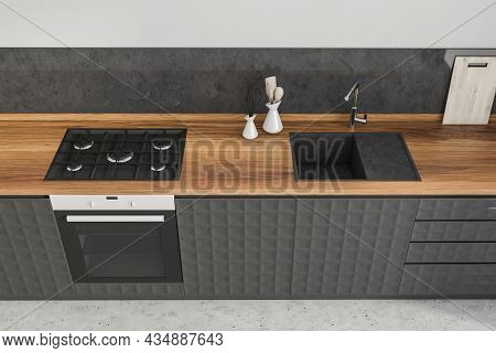 Top View Of The Stylish Black Kitchen With Textured Cabinets, A Wood Worktop And A Dark Sink With A 