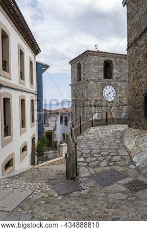 Narrow Streets Of The Fishing Village Of Lastres, Asturias, Spain, With The Clock Tower Of The Town 
