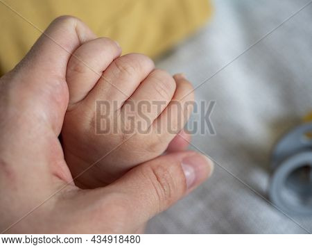 Close-up Of A Woman's Hand Holding The Handle Of A Small Child. The Concept Of Child Protection, Car