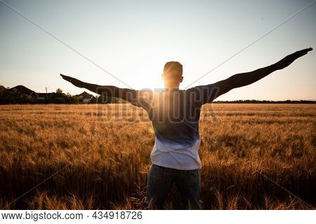 Unspecified Man With Hands Up Watching Sunset