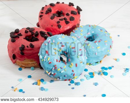 Red And Blue Cronuts On A White Wooden Background. High Quality Photo