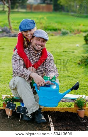 Gardening, planting - young girl helping father in the garden