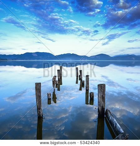 Wooden Pier Or Jetty Remains On A Blue Lake Sunset And Sky Reflection On Water. Versilia Tuscany, It