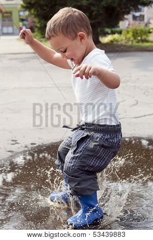 Child Jumping In Puddle