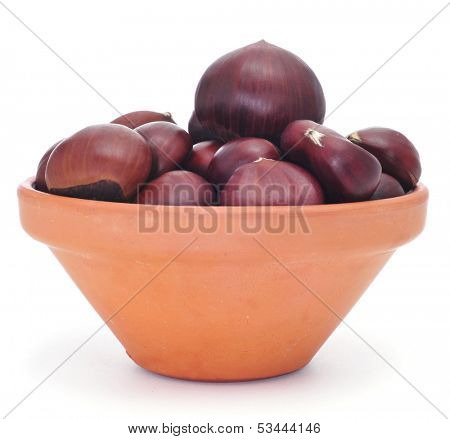 an earthenware bowl with chestnuts on a white background