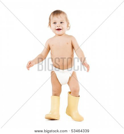 childhood and toys concept - cute little boy walking in big rubber boots