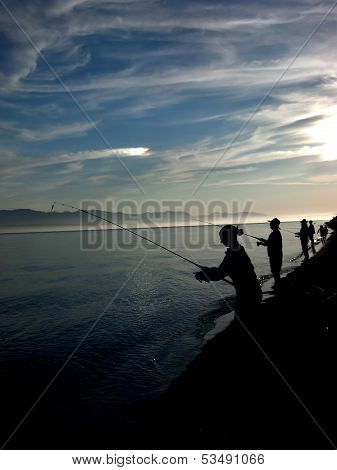 Silhouettes Fishing On The Shore