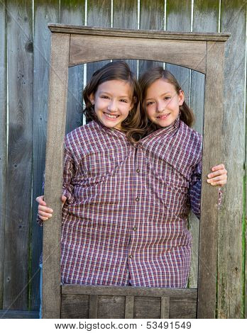 twin girls fancy dressed up pretending be siamese with dad shirt playing with grunge border frame
