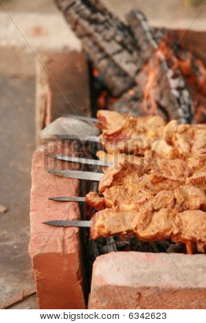 Шашлык готовится на природе на кирпич.Свежее мясо