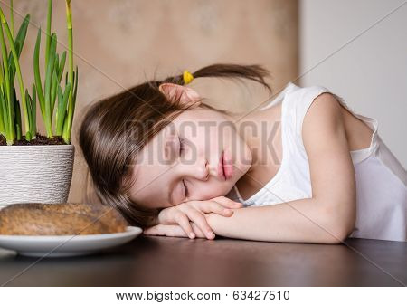 Tired preschooler girl in the kitchen