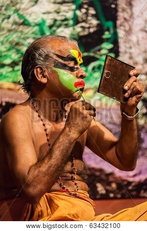 KOCHI, INDIA - FEBRUARY 24, 2013: Unidentified Kathakali exponent preparing for performance by applying face make-up. Kathakali is the classical dance form of Kerala