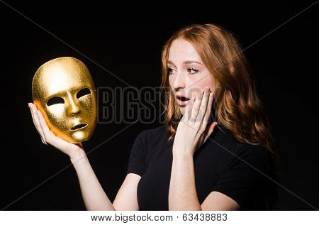 Redhead woman iwith mask in hypocrisy consept against black  background