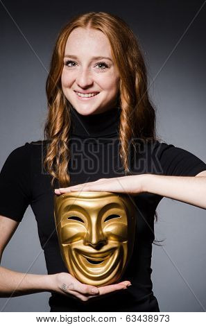 Redhead woman iwith mask in hypocrisy consept against grey background