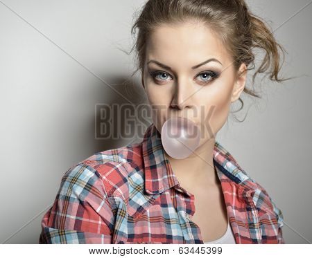 Beautiful teen girl inflating bubble of chewing gum. Moderm fashion girl.