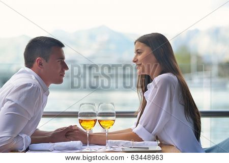 happy young couple having lanch at beautiful restaurant on by the sea on  beach